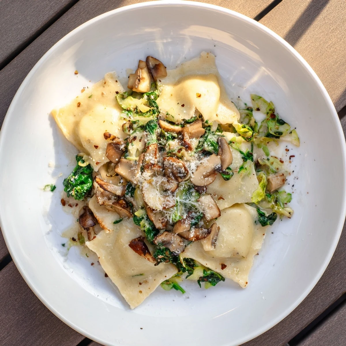 Delicious, creamy One-Dish Mushroom and Spinach Gnocchi, glistening and ready to serve with Parmesan cheese.