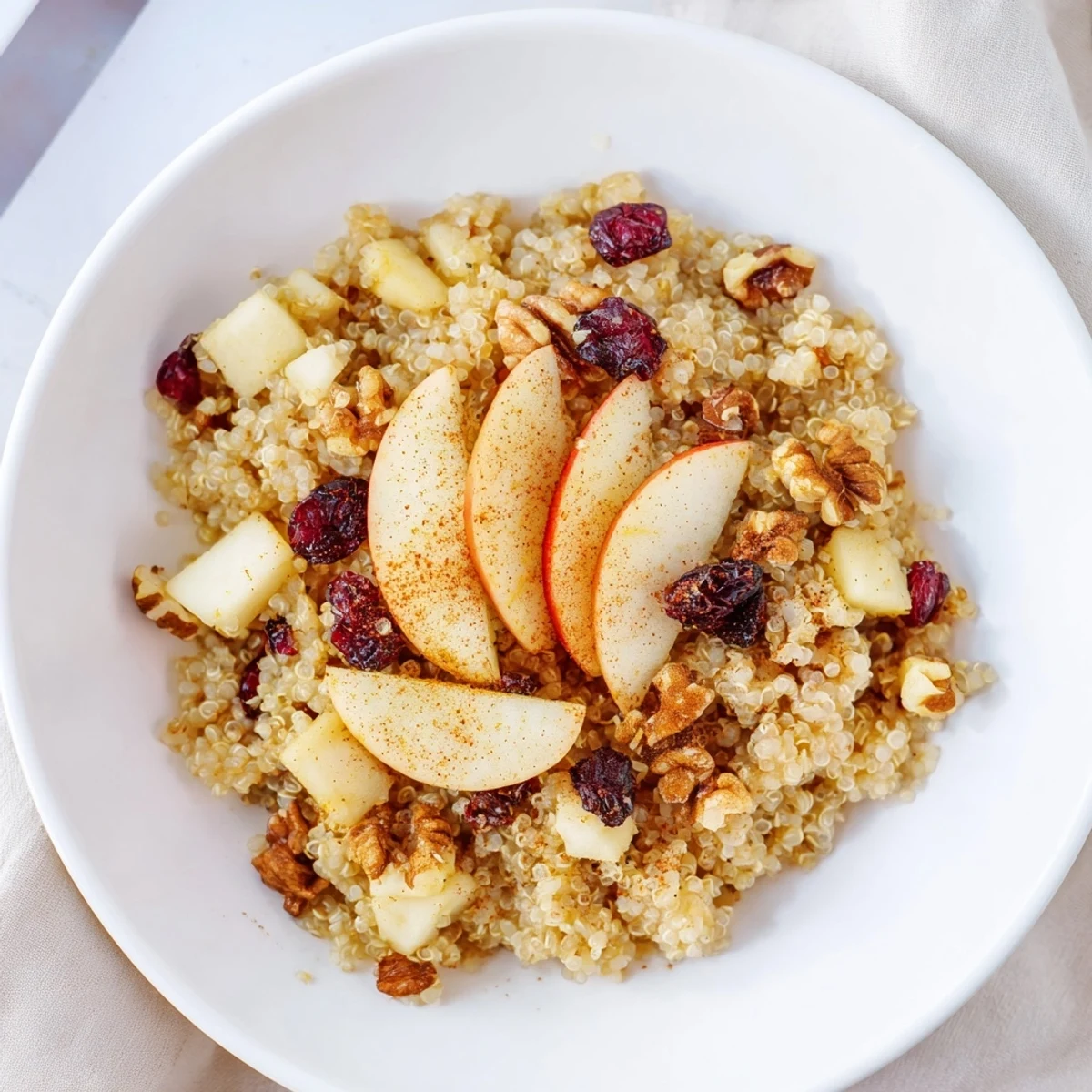 This flavorful Apple Cinnamon Quinoa Bowl boasts soft apples and cozy spices, a delicious and gluten-free treat.