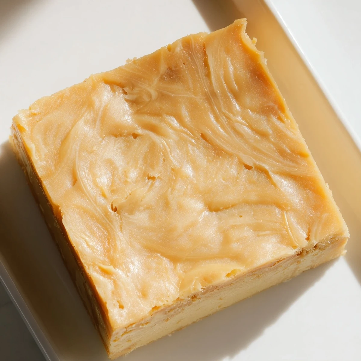 Warm, golden Peanut Butter Mochi Cake, a chewy dessert with delightful peanut butter swirls, ready to slice.