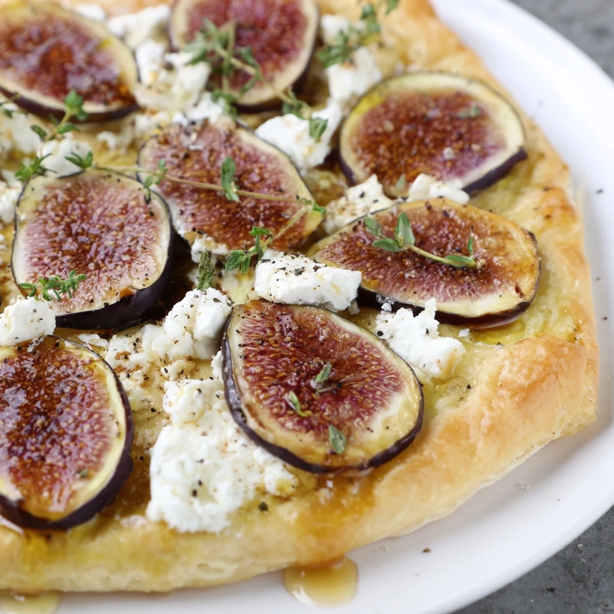 Crispy puff pastry truffle pizza featuring sweet figs, honey, and creamy goat cheese, ready to serve.