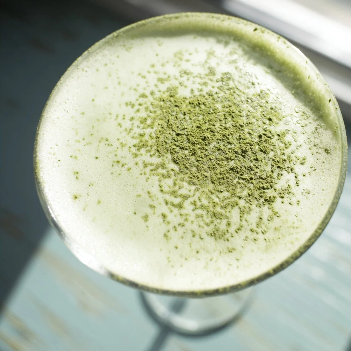 Vibrant green Matcha Martini cocktail with a frothy head, served ice-cold in a classic martini glass.