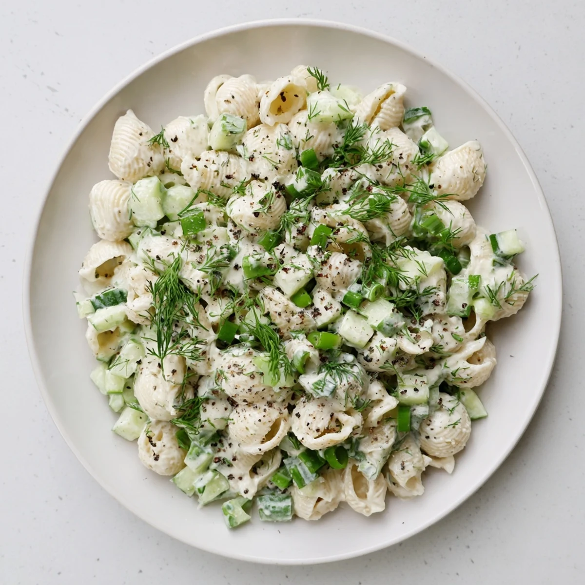 Close-up of Cucumber Crunch Pasta Salad showing chilled pasta, crisp cucumbers, and herbs tossed in tangy dressing, perfect for summer picnics.