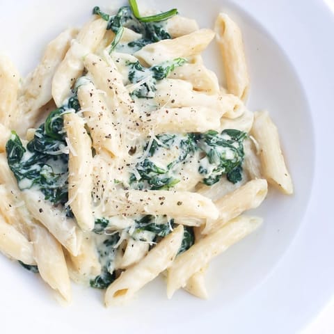Close-up of Creamy Spinach Pasta, showing tender spinach and cheesy, luscious sauce.