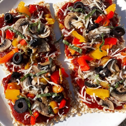 Golden and bubbly Rice Cake Pizza Squares, topped with olives and bell peppers, are a tasty appetizer.