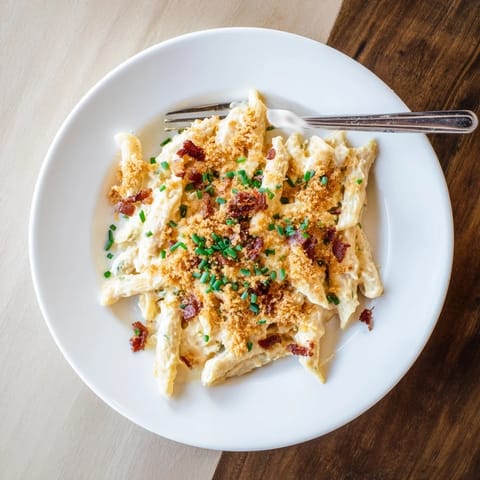 A bowl of hearty Jalapeño Popper Pasta garnished with toasted panko, offering a spicy yet comforting main dish.