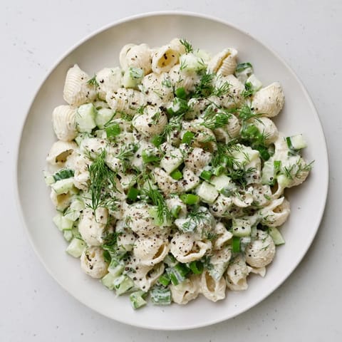 Close-up of Cucumber Crunch Pasta Salad showing chilled pasta, crisp cucumbers, and herbs tossed in tangy dressing, perfect for summer picnics.