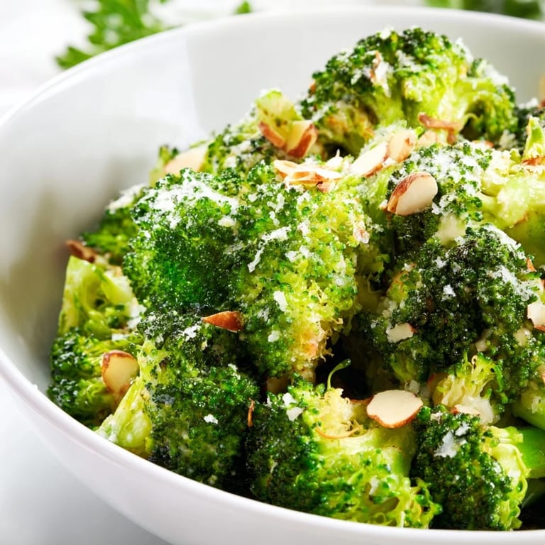 Creamy garlic Parmesan broccoli salad with red onion and almonds, perfect as a fresh lunch or picnic side.