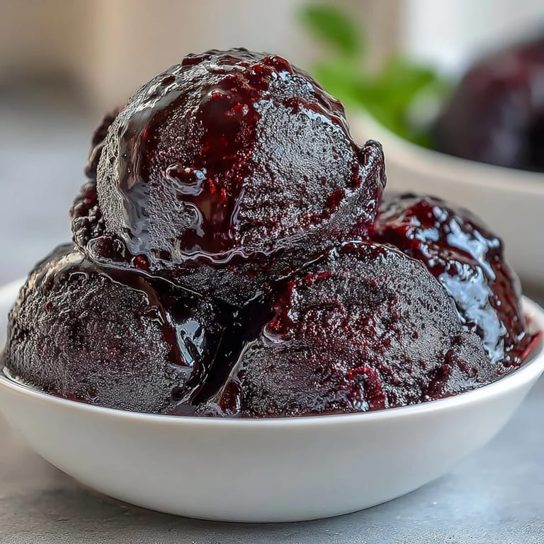 Smooth and refreshing black currant sorbet with a tangy-sweet flavor, perfect for cooling off on a hot summer day.