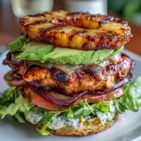 Grilled chicken pineapple burger stacks with juicy chicken, caramelized pineapple, and crisp vegetables layered high.  